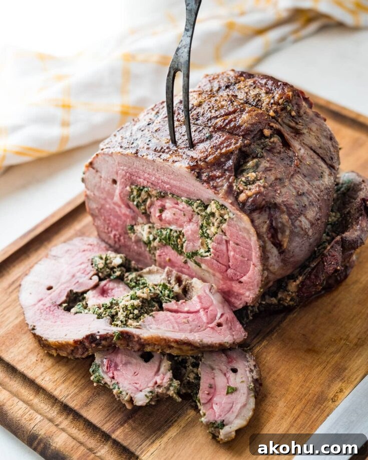 slicing the stuffed leg of lamb on a cutting board.