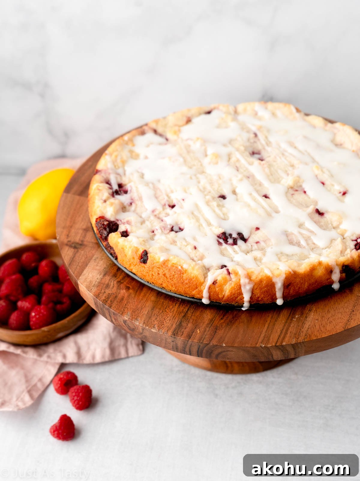 Lemon-Glazed Raspberry Ricotta Cake: Moist Italian Dessert 2 Raspberry ricotta cake with lemon glaze on a cake stand.