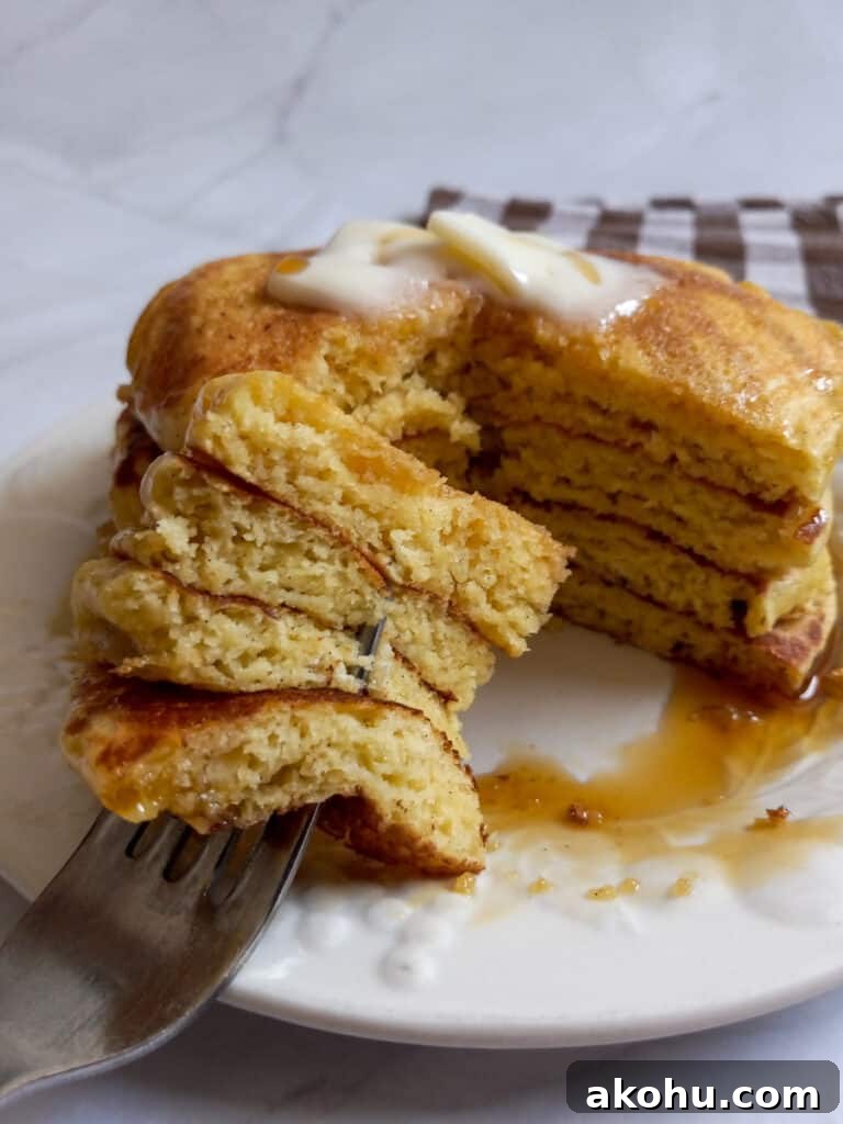 A chunk taken out of a stack of fluffy pancakes
