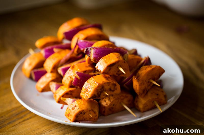 BBQ paprika sweet potato skewers with a lemon tahini sauce make a fantastic vegetarian and vegan BBQ grilled side dish to serve up this summer or can go with meat, fish and cheese really well. Using just sweet potato, and red onion coated in warming paprika, plus a sauce of tahini, lemon juice and gentle cinnamon, topped with coriander, these skewers are sure to make everyone around the lunch or dinner table happy!