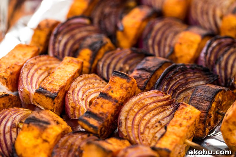 BBQ paprika sweet potato skewers with a lemon tahini sauce make a fantastic vegetarian and vegan BBQ grilled side dish to serve up this summer or can go with meat, fish and cheese really well. Using just sweet potato, and red onion coated in warming paprika, plus a sauce of tahini, lemon juice and gentle cinnamon, topped with coriander, these skewers are sure to make everyone around the lunch or dinner table happy!