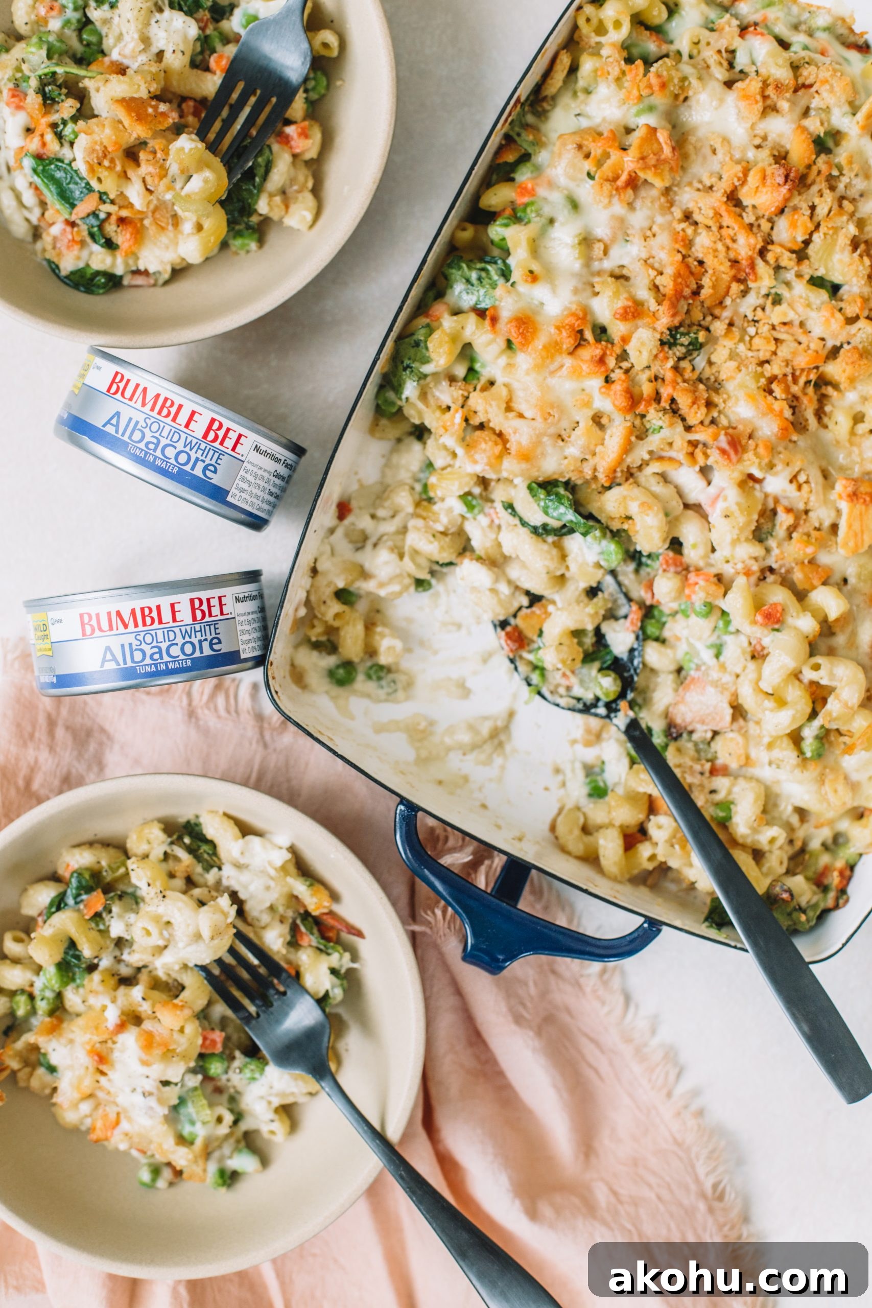 Homemade Tuna Noodle Casserole Recipe From Scratch 10 Tuna noodle casserole being served into tan bowls with a can of tuna.