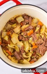 A delightful cabbage stew recipe featuring a pot filled with tender corned beef, savory cabbage, and vibrant carrots.