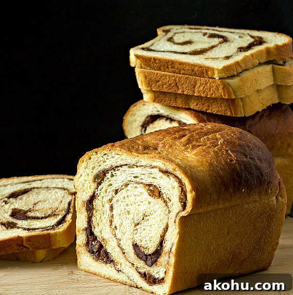 Why Cinnamon Swirl Bread Splits During Baking — How to Prevent It 6 a sliced loaf of cinnamon raisin swirl bread with stacked up slices