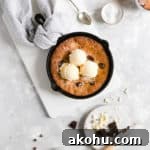 overhead shot of skillet cookie topped with 3 scoops of vanilla ice cream