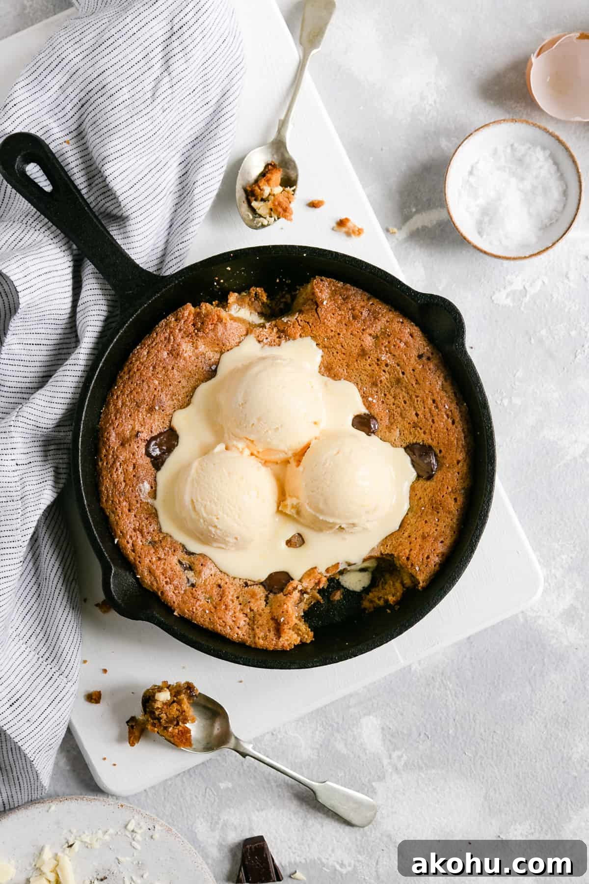 overhead shot of chocolate chip and malted milk cookie in the skillet with a spoonfull taken out