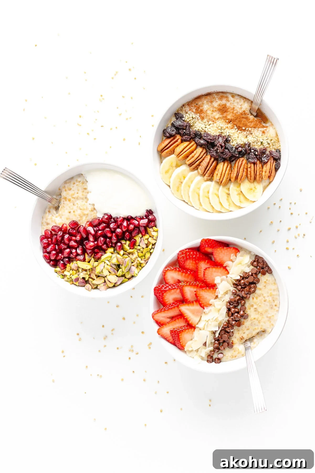 Three bowls of steel cut oatmeal with different toppings on a white background scattered with steel cut oats.