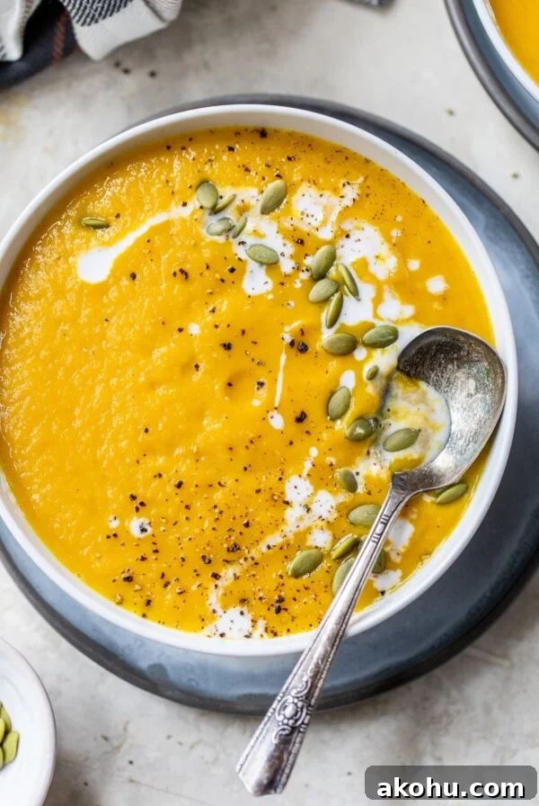 a bowl of blended soup topped with pumpkin seeds