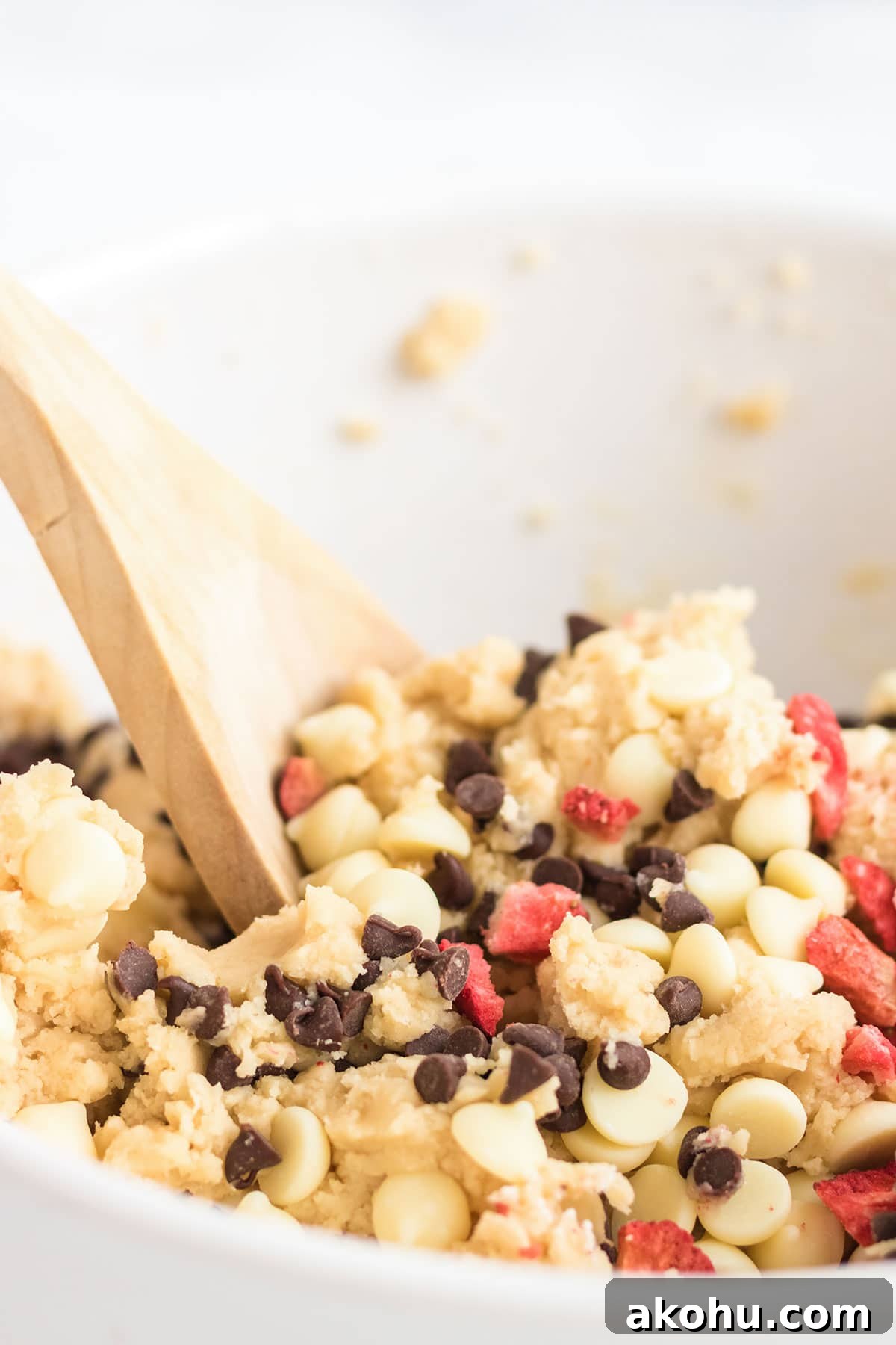 Mixing up the strawberry cheesecake cookie batter with a wooden spoon.
