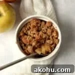 Single serve apple crisp in a ramekin with an oat topping.