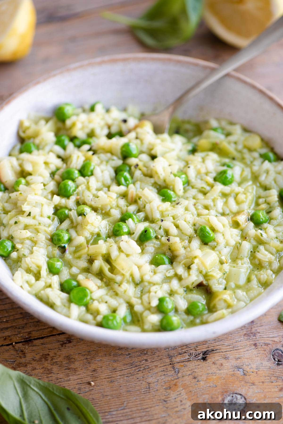 Creamy Pea and Basil Pesto Risotto 7 A side shot of a pea and pesto risotto in a bowl in a wooden surface with a fork at the side
