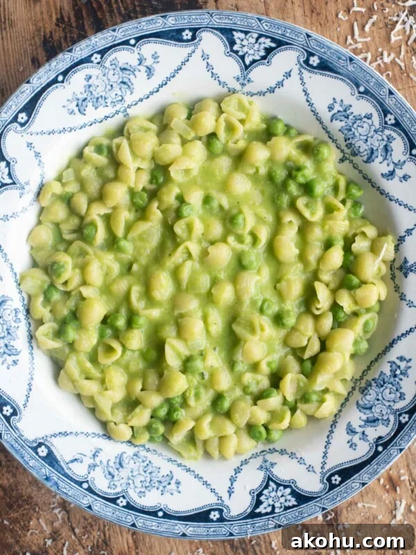 Creamy Pea and Basil Pesto Risotto 9 An overhead shot of Pasta and Piselli (peas) in a blue bowl sitting on a wooden surface.