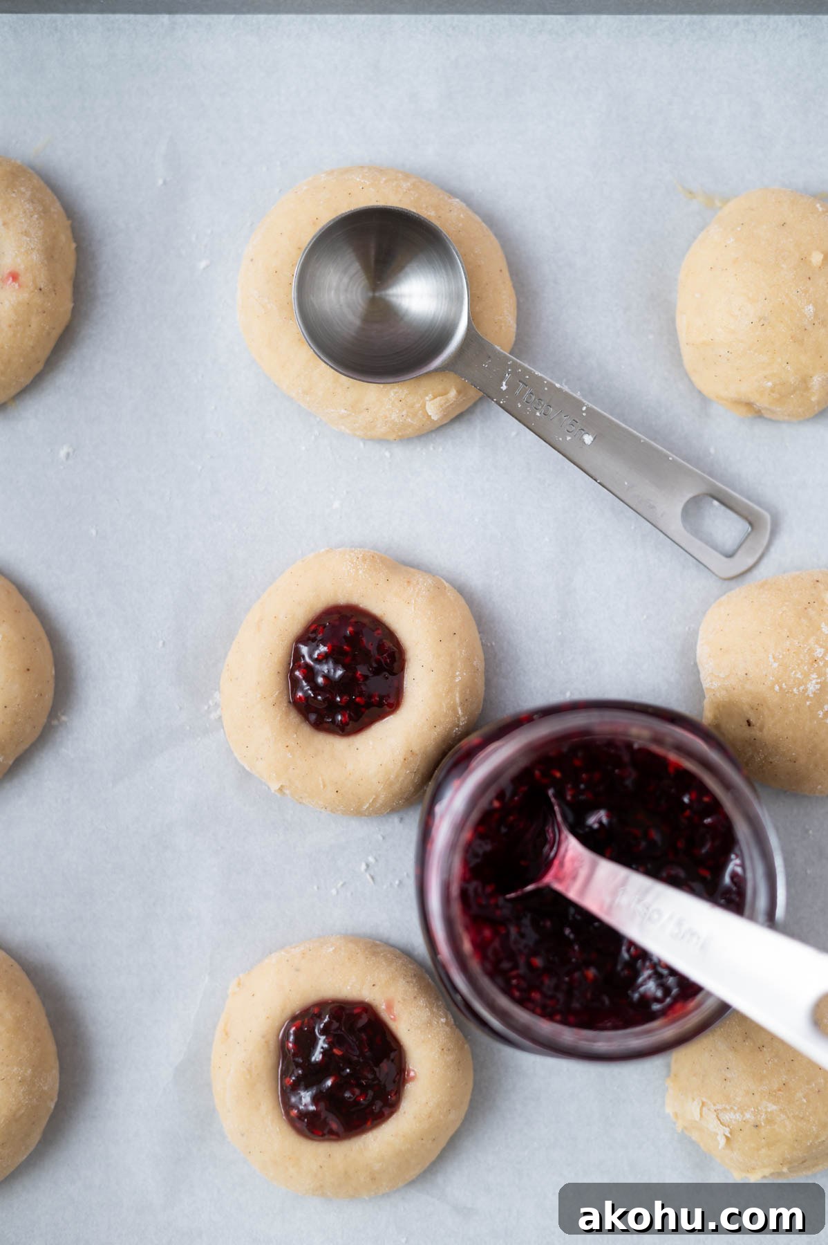 Yeast-Raised Baked Raspberry Donuts: Soft, Glazed Recipe 9 tablespoon pressing indents into the center of donuts with raspberry jam