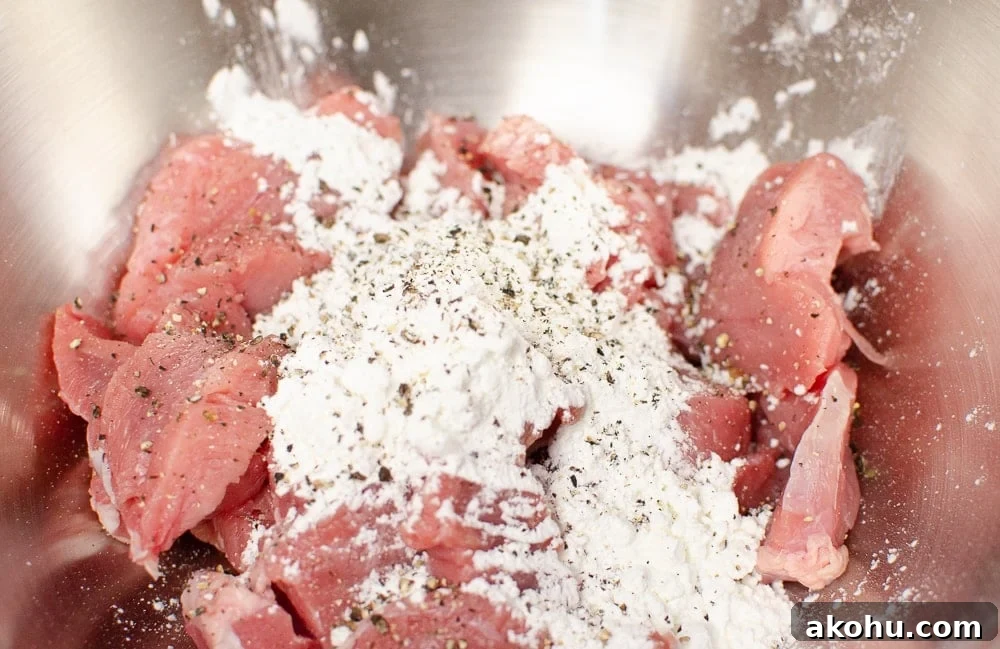 pork coated in cornstarch and black pepper in a silver bowl to make sizzling spicy pork