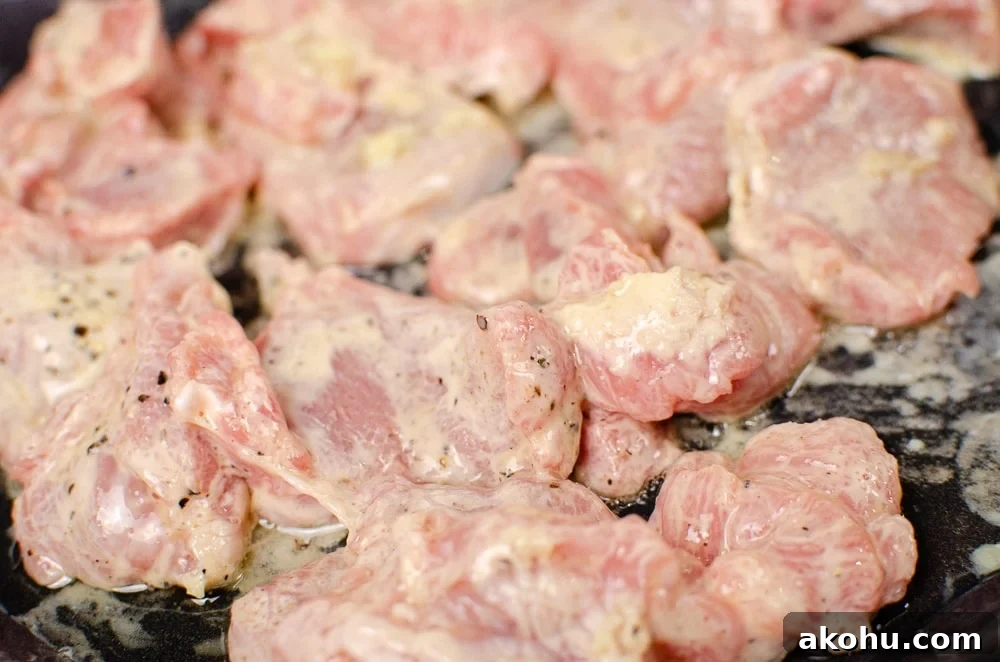 pork being cooked in a cast iron pan to make our sizzling spicy pork