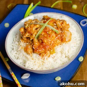 Diced Pork fillet with a spicy sauce served on rice with spring onions and sesames seeds scattered on top.
