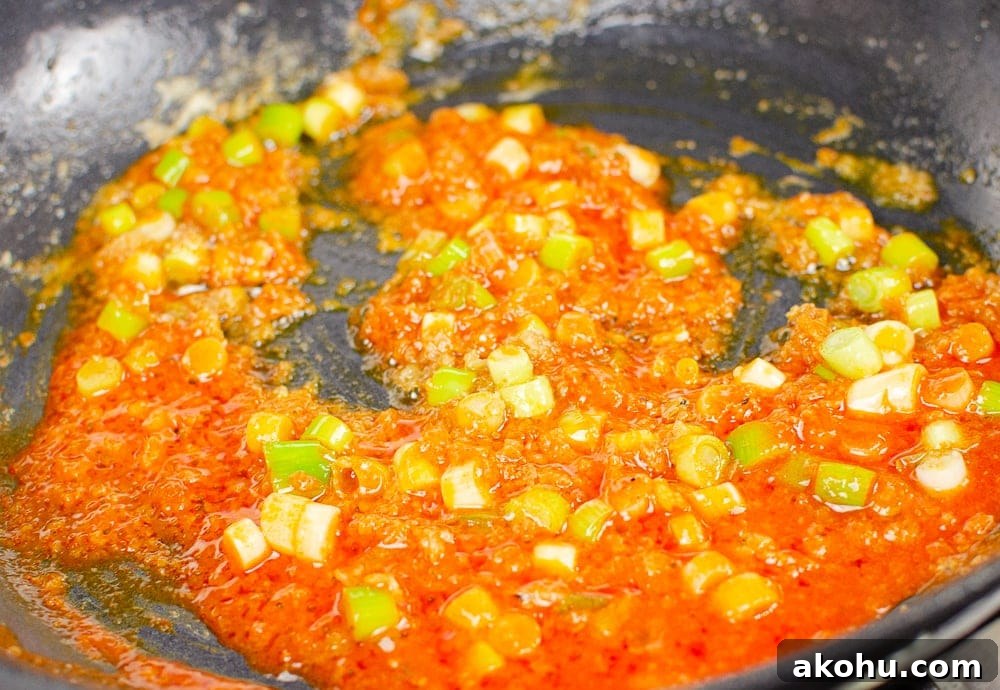 Franks hot sauce being stirred together with spring onions.