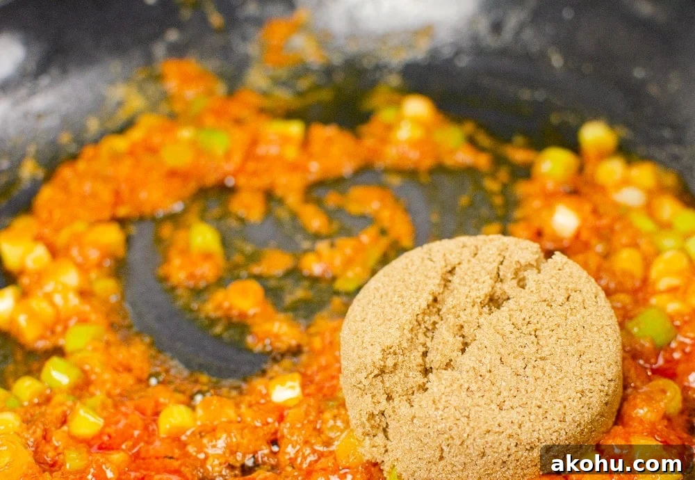 Franks hot sauce being stirred together with spring onions to make our sizzling spicy pork