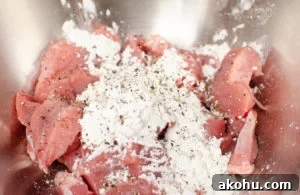 pork coated in cornstarch and black pepper in a silver bowl to make sizzling spicy pork