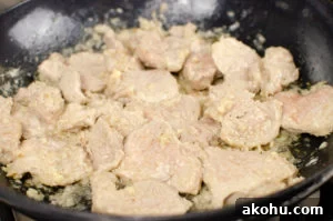pork being cooked in a cast iron pan to make our sizzling spicy pork
