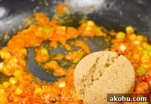 Franks hot sauce being stirred together with spring onions to make our sizzling spicy pork