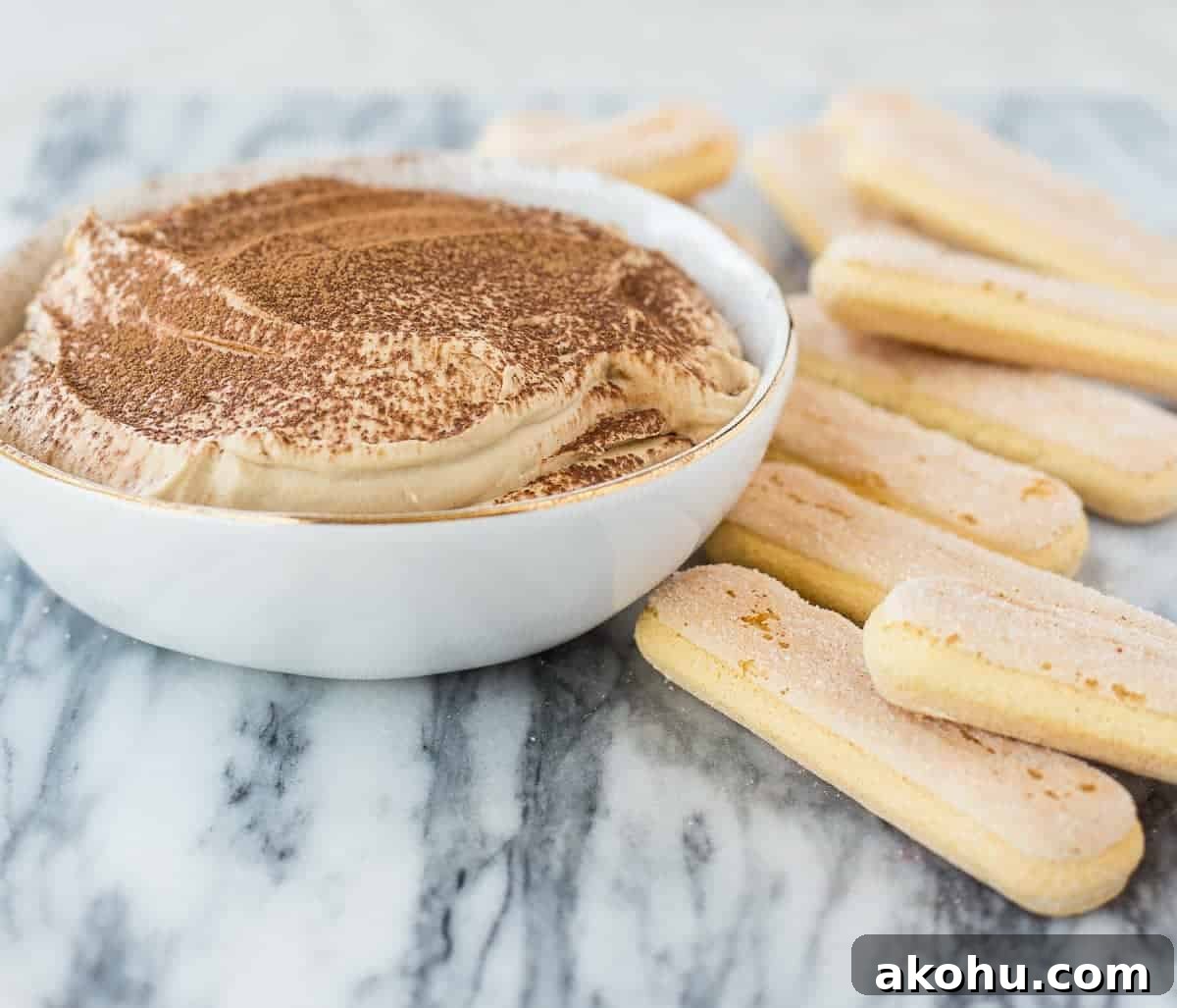 10-Minute Tiramisu Dip: Creamy Espresso Mascarpone Recipe 3 Front view of dip in bowl, with lady fingers alongside.