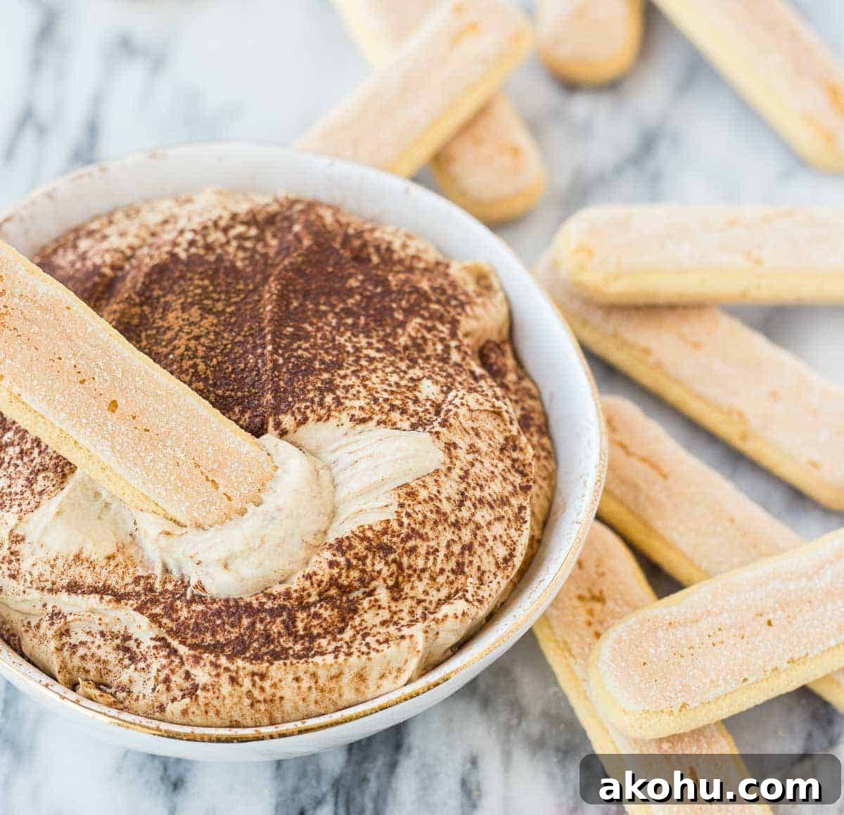 10-Minute Tiramisu Dip: Creamy Espresso Mascarpone Recipe 5 Closeup of dip in decorative bowl, shown with a ladyfinger scooping out dip.