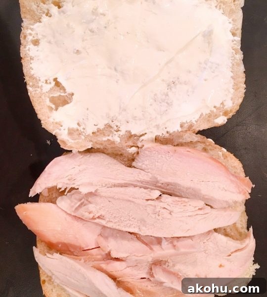 ciabatta roll cut in half length wise and topped with cream cheese spread and turkey.