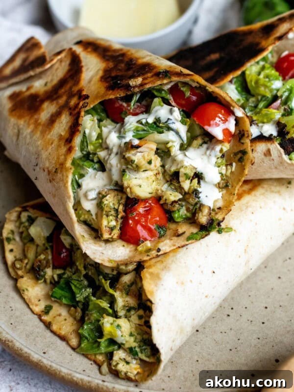 Chicken wraps with pesto and in a wrap on a ceramic plate.