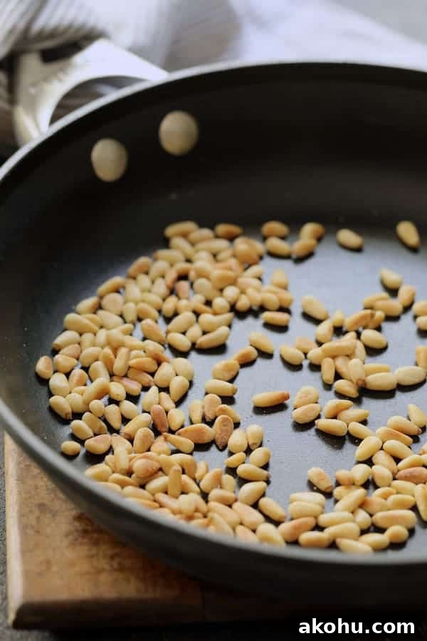 Photo of toasted pine nuts in nonstick skillet.