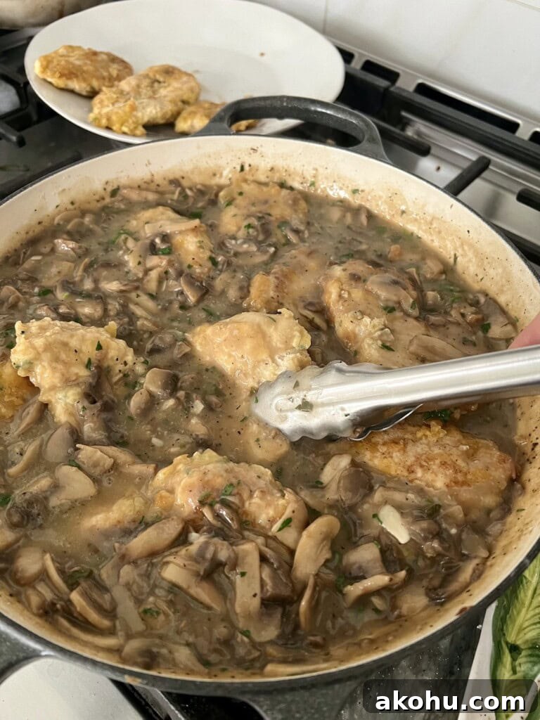 Adding cooked chicken pieces back to pan in sauc.