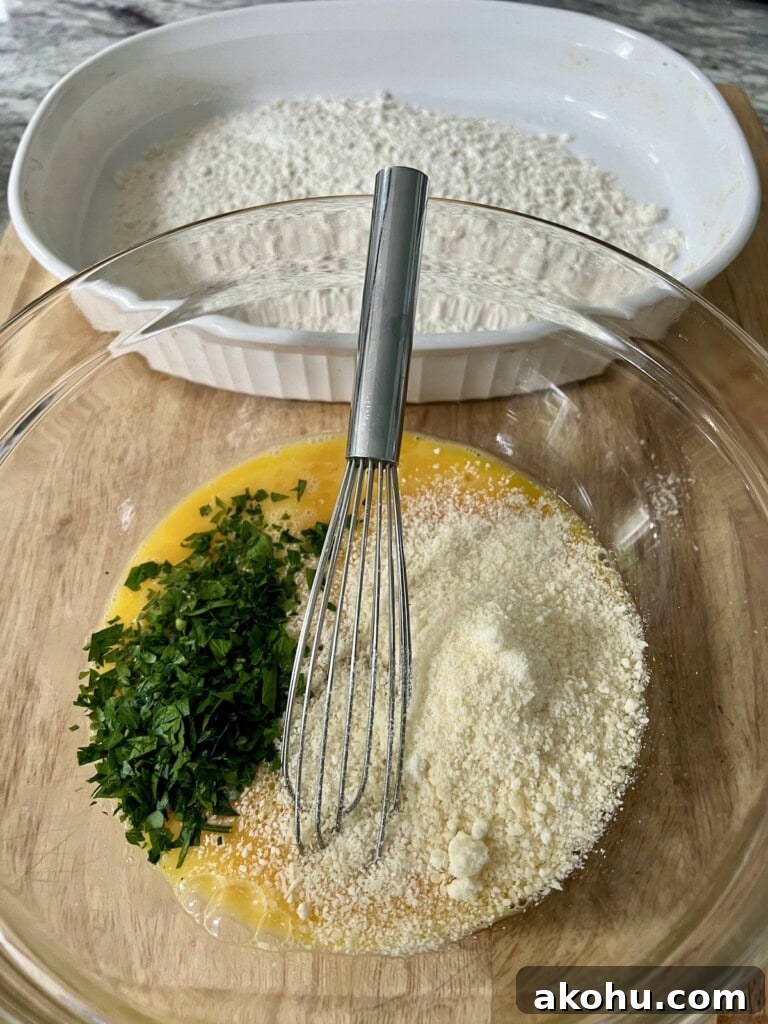 Eggs, chopped parsley and grated cheese in bowl about to be mixed together, with flour in the backgound.
