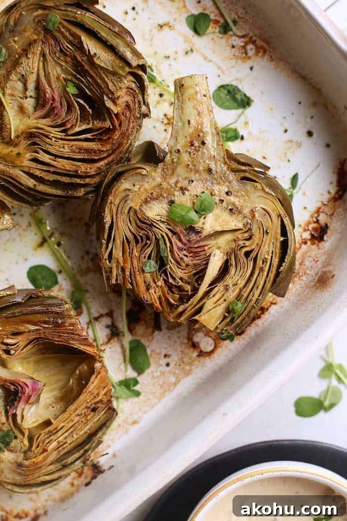 These bright and nutty oven roasted artichokes with dairy-free creamy cashew aioli make the perfect side dish or appetizer. Vegan and gluten-free.