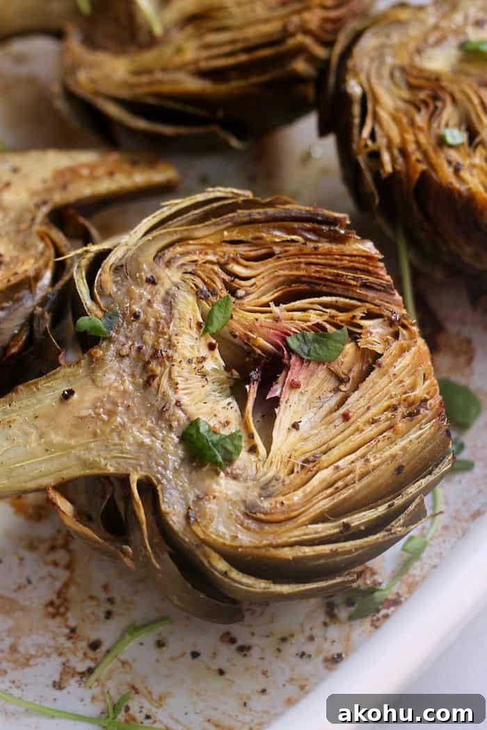 These bright and nutty oven roasted artichokes with dairy-free creamy cashew aioli make the perfect side dish or appetizer. Vegan and gluten-free.