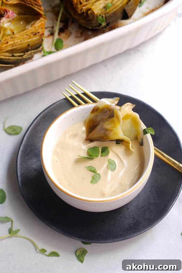 These bright and nutty oven roasted artichokes with dairy-free creamy cashew aioli make the perfect side dish or appetizer. Vegan and gluten-free.