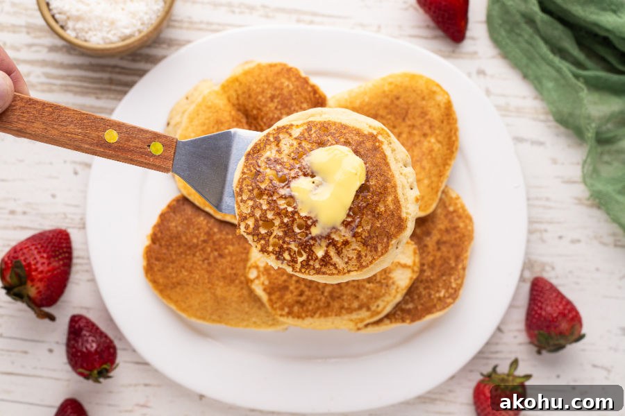Spatula holding a buttered pancake.
