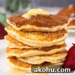 Stack of pancakes topped with butter and syrup.