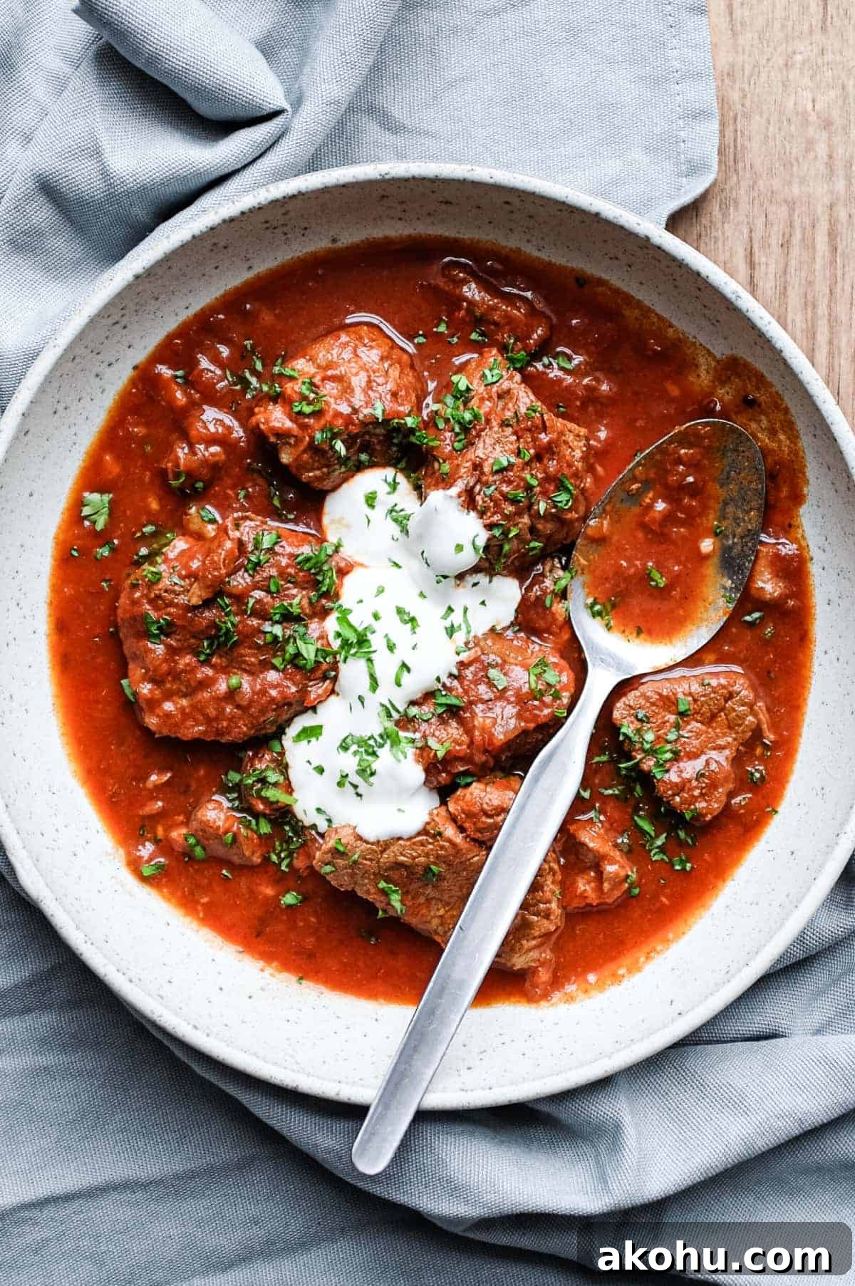 A bowl or Hungarian Pörkölt Beef Stew in a bowl, wrapped in a tea towel.