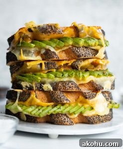 3 sandwiches stacked on each other on small marble plate