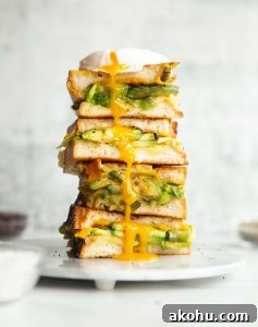 3 sandwich halves stacked on each other on small marble plate