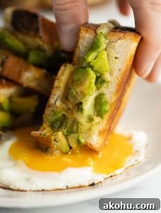 close up shot of sandwich being dunked into fried egg