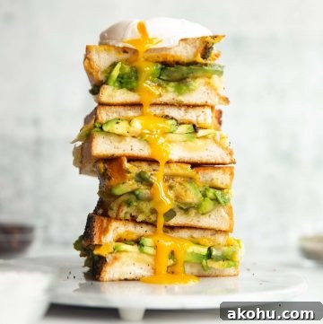 3 sandwich halves stacked on each other on small marble plate