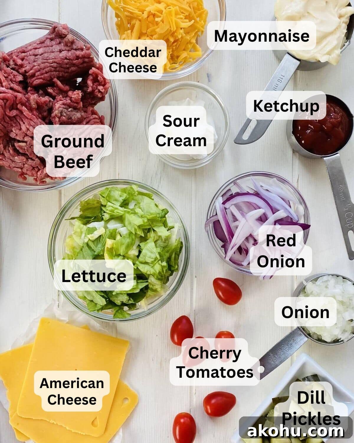 Ingredients for Big Mac bowls including ground beef, onion, American cheese, cherry tomatoes, lettuce and dill pickles.