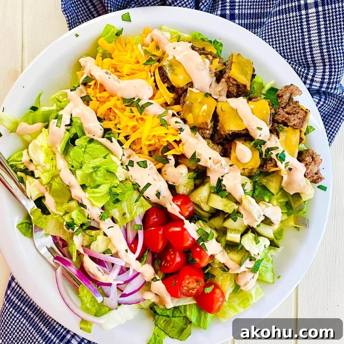 A Big Mac Bowl cheeseburger salad with a blue napkin.