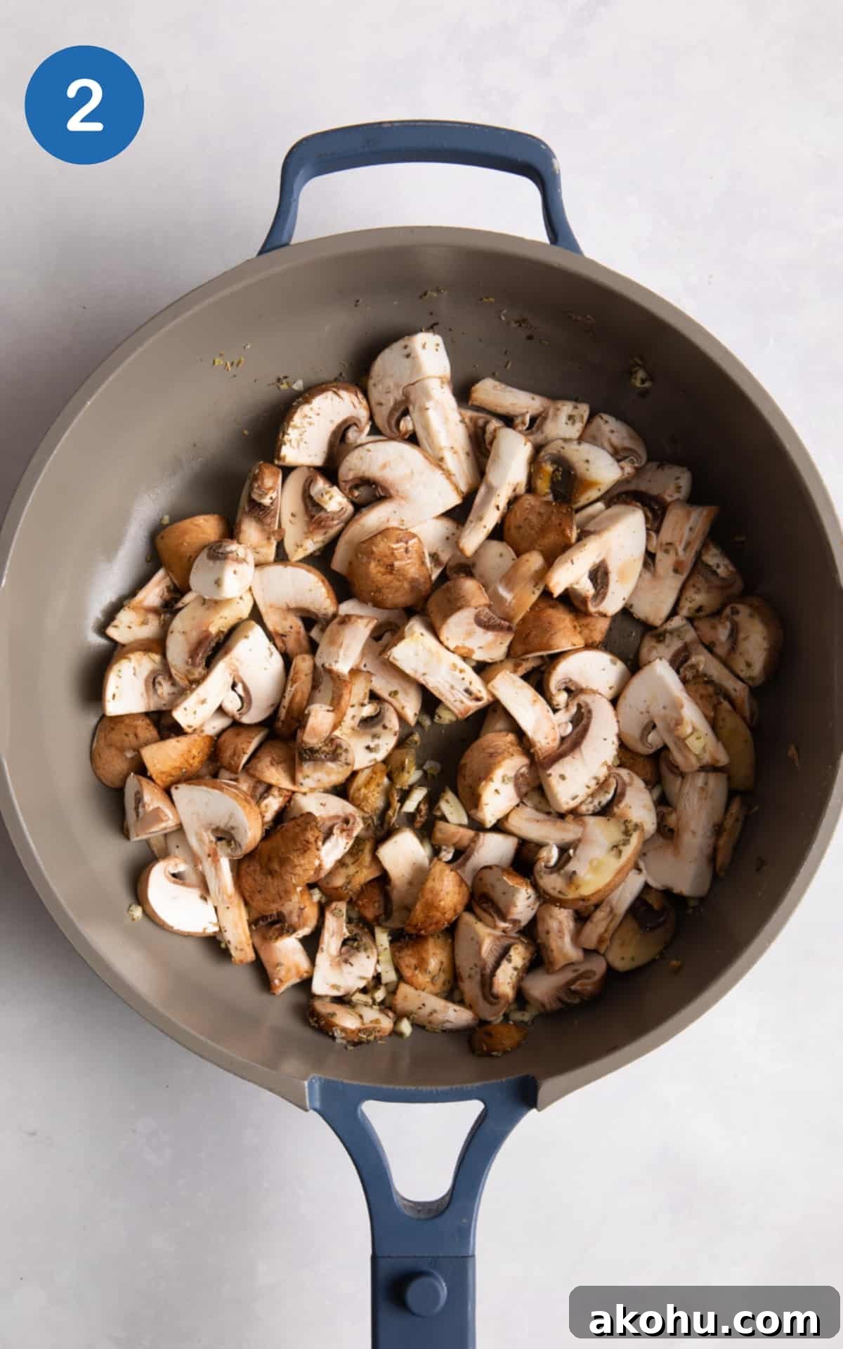 mushrooms in blue frying pan on white surface.