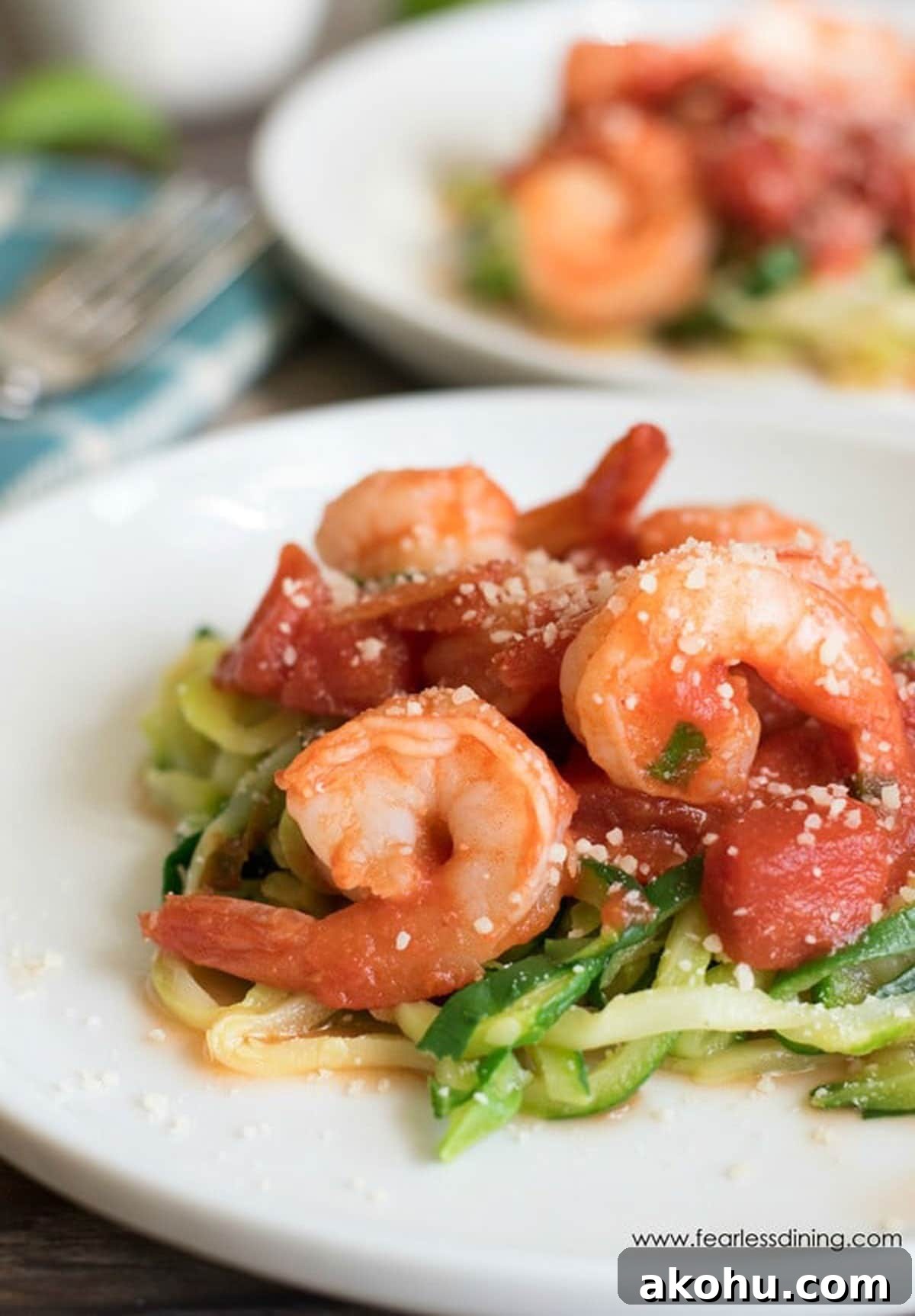 Two plates of shrimp diavolo over zucchini noodles.