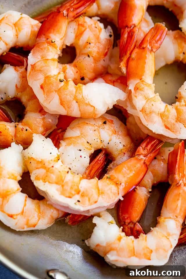 This creamy coconut shrimp recipe is bursting with delicious Thai-inspired flavors and is ready in 20 minutes. Cooked shrimp in a skillet.