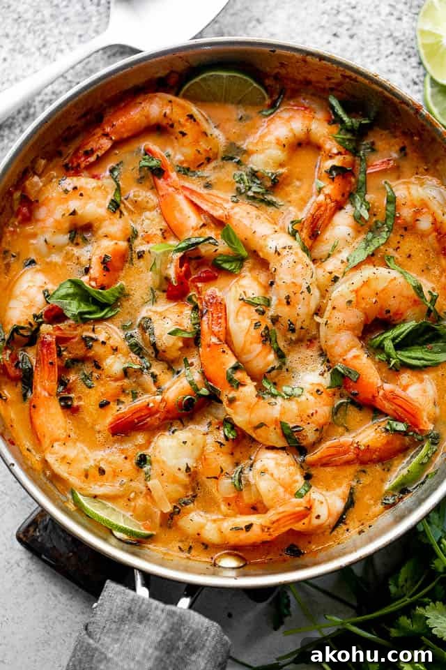 This creamy coconut shrimp recipe is bursting with delicious Thai-inspired flavors and is ready in 20 minutes. wide overhead shot of shrimp in a skillet with coconut sauce