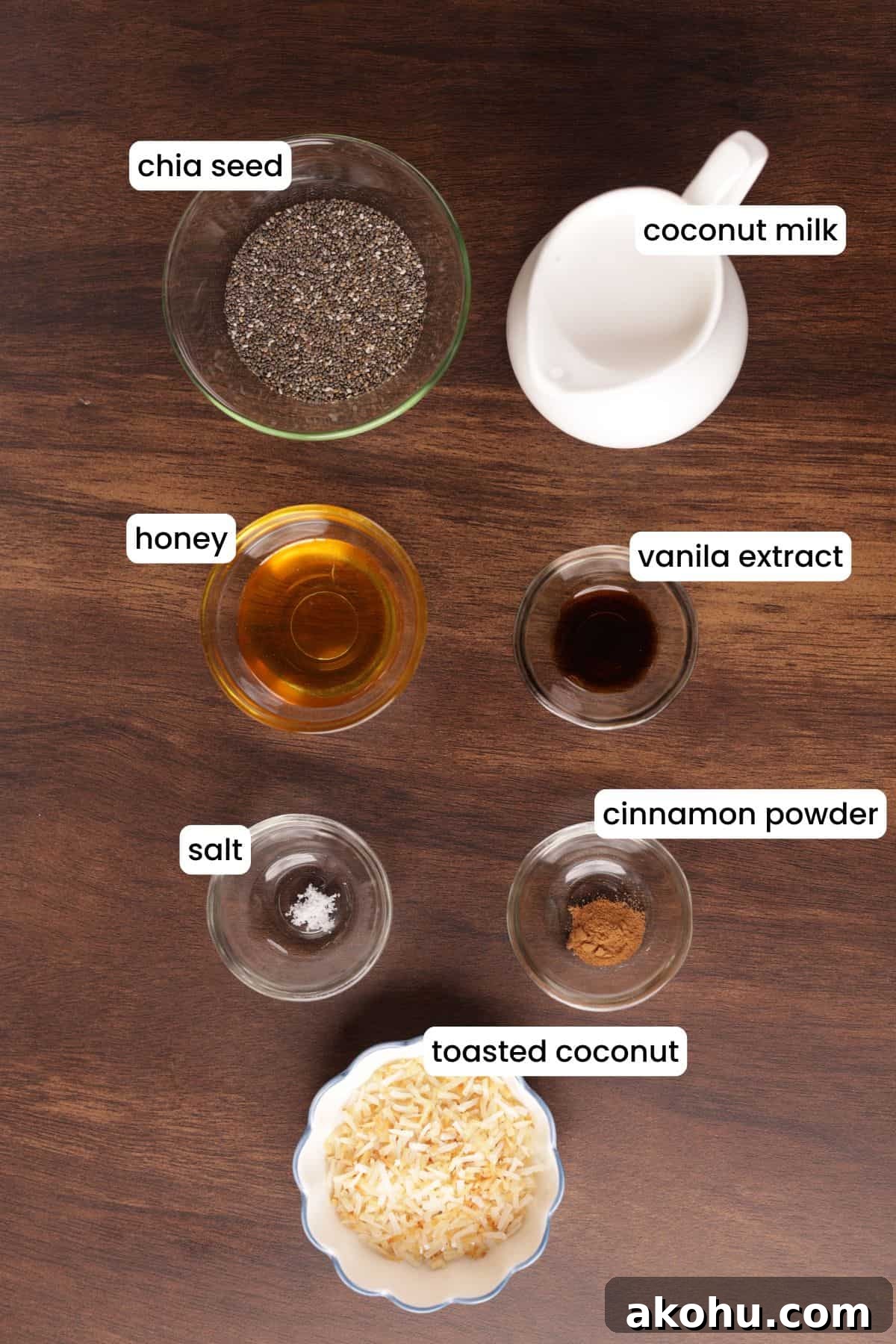 Creamy Coconut Chia Pudding Recipe for a Satisfying Breakfast 3 Ingredients for coconut chia seed pudding arranged on a wooden background, including chia seeds, coconut milk, honey, vanilla, cinnamon, salt, and toasted coconut.
