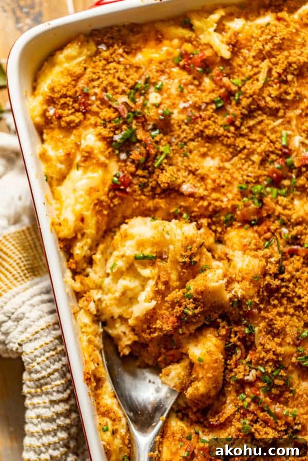 twice baked mashed potatoes in a baking dish topped with crispy breadcrumbs, bacon bits, and fresh chives.